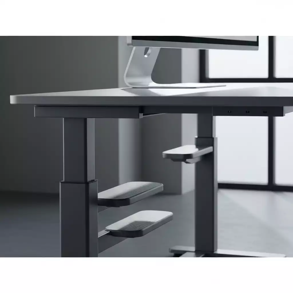 Close-up of an adjustable standing desk with a monitor, showing height adjustment mechanism and minimal design