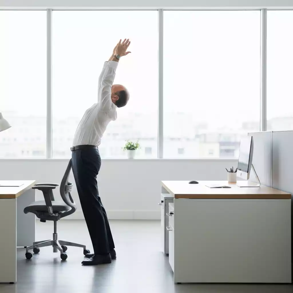 Person doing a simple desk stretch in a modern office cubicle